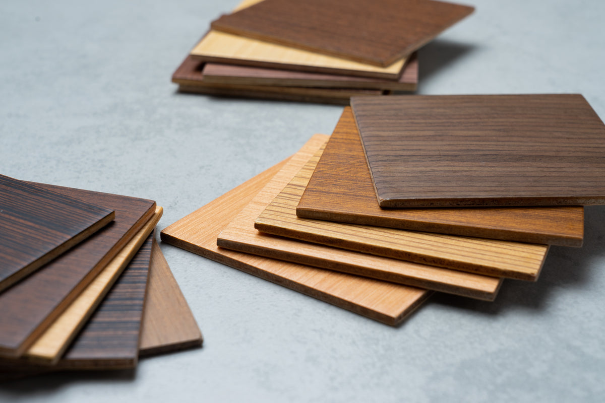 Stacked wood cabinet material samples in light and dark finishes