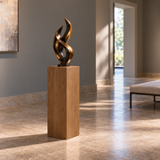Titan Clear Alder display pedestal, 11 × 11 × 30 inches, Rubio Monocoat Walnut, styled in a gallery. Illustrative room scene; artwork not included.