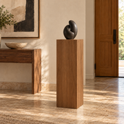 Titan Clear Alder display pedestal, 16 × 16 × 36 inches, Rubio Monocoat Walnut, in a entry setting. Illustrative room scene; artwork not included.