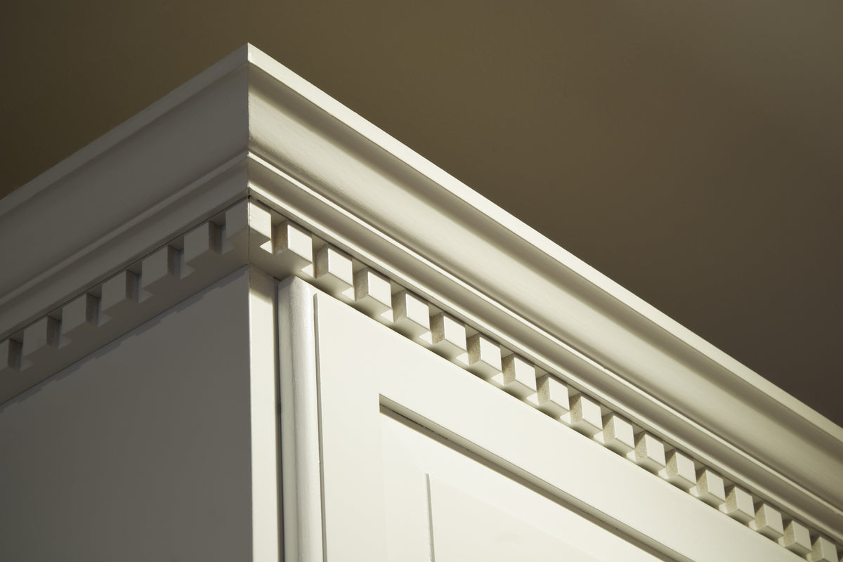 White cabinet crown moulding with a dentil trim detail