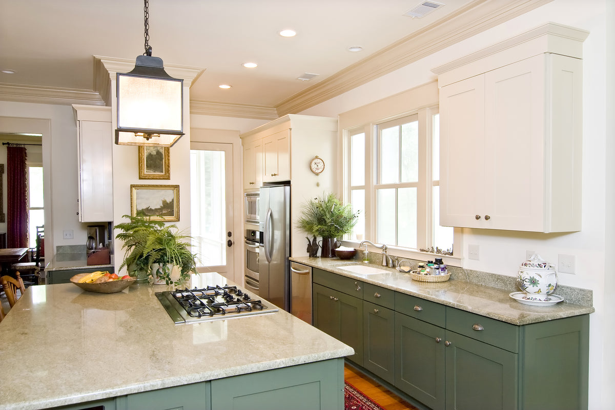 Kitchen with white upper cabinets, green lower cabinets and crown moulding