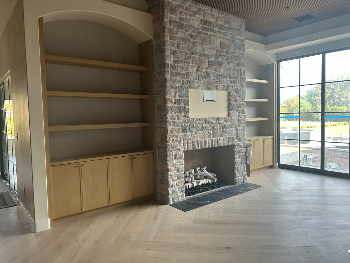 Custom fireplace wall with floating shelves and built-in cabinetry