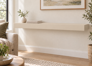 42-inch long, 3-inch thick standard painted floating shelf in Natural Linen SW 9109, unlit living-room rendering.