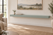 54-inch long, 3-inch thick standard painted floating shelf in Halcyon Green SW 6213, unlit living-room rendering.
