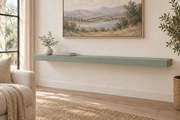 60-inch long, 3-inch thick standard painted floating shelf in Halcyon Green SW 6213, unlit living-room rendering.