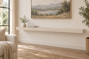 60-inch long, 3-inch thick standard painted floating shelf in Natural Linen SW 9109, unlit living-room rendering.