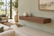 24-inch long, 4-inch thick natural walnut floating shelf, standard mount, unlit, living-room rendering