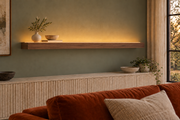 66 × 8 × 3 inch natural walnut floating shelf, standard mount, LED-ready Top Front location shown with separately supplied lighting, living-room rendering