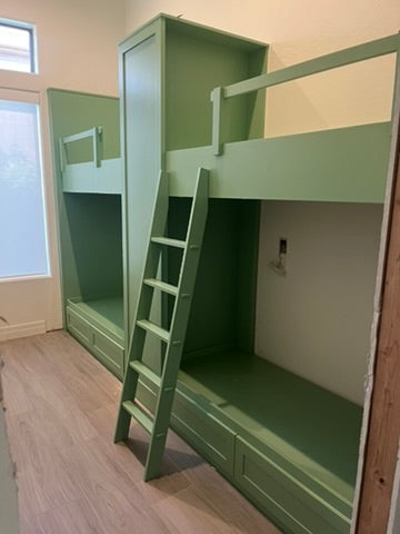 Custom green built-in bunk beds with integrated drawers and ladder