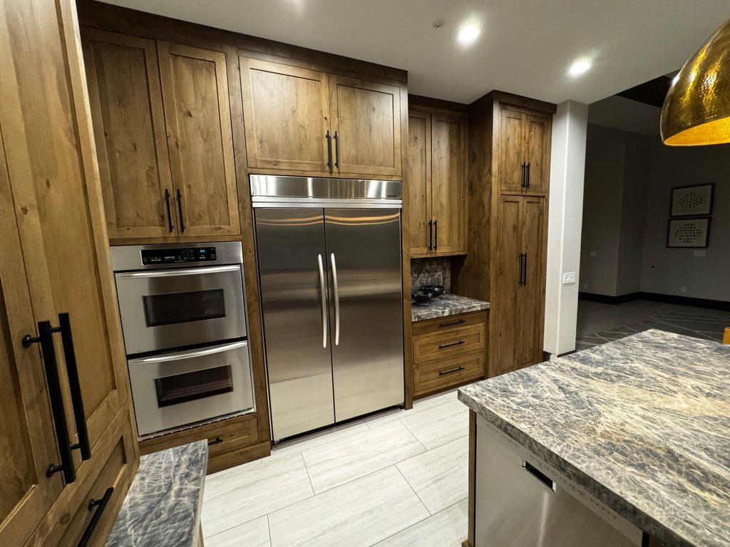 Custom rustic wood kitchen cabinetry with integrated appliances
