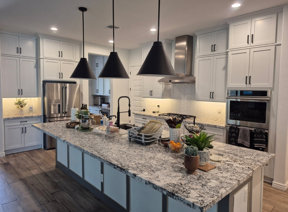 Custom white kitchen cabinetry with black hardware and large island