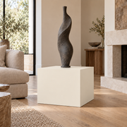 Creamy SW 7012 painted display pedestal in a 02 low living room broad setting; representative room rendering.