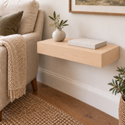 Maple floating shelf in Unfinished / Stain Ready, Standard mount; unlit representative compact-proportion room rendering, not dimension-specific.